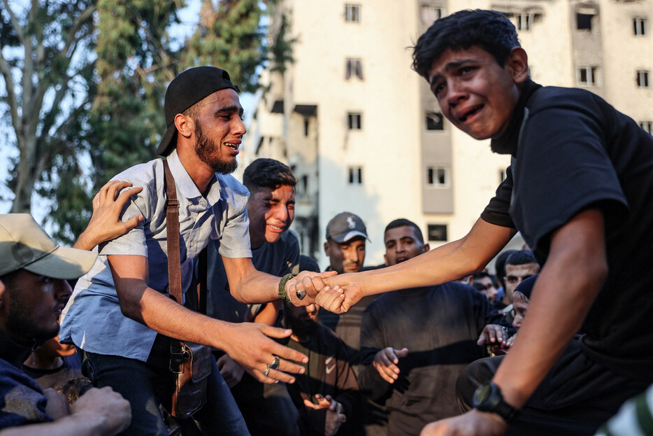 イスラエル軍は７日、パレスチナ自治区ガザ北部のガザ市で避難民が身を寄せる学校を空爆し、少なくとも１０人が死亡した。写真は学校空爆の犠牲者を悼む人々。