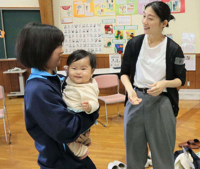 赤ちゃんを抱っこしてあやす生徒（京丹波町市場・和知中）