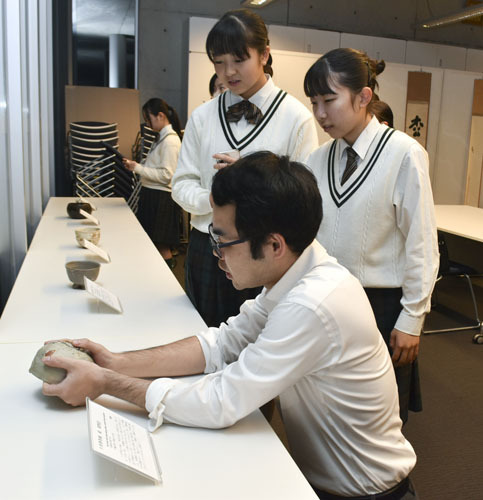 【桐田学芸員（手前）から茶わんの説明を聞く生徒＝津市垂水の石水博物館で】