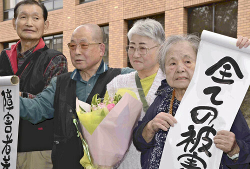 和解成立を喜ぶ尾上敬子さん（右から２人目）、一孝さん（同３人目）（１５日、名古屋高裁前で）