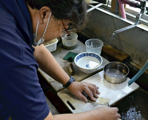 鉄に鍍金する失われた技術の再現をめざして作業する治村さん（京都府宇治市で）