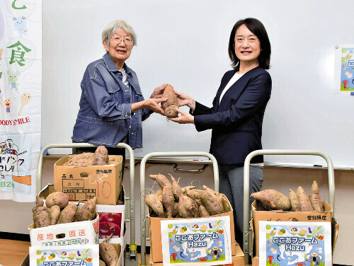 農場で収穫されたサツマイモを布間代表（左）に寄贈する中島事務局長（愛知県西尾市で）