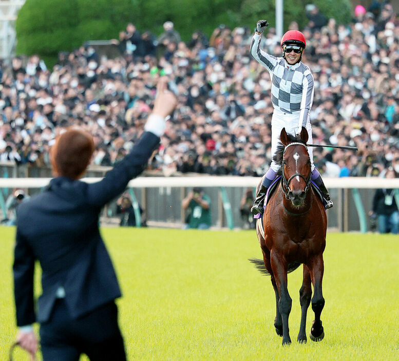 ウイニングランで前川助手（左）に向かってガットポーズをするドウデュースの武豊騎手（カメラ・高橋　由二）