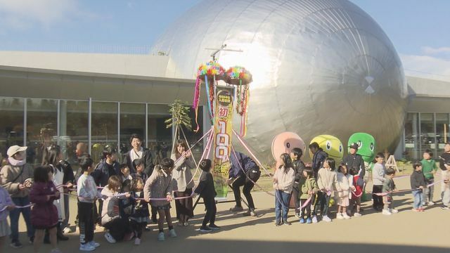 セレモニーでくす玉を割る子どもら＝24日午前10時、勝山市の県立恐竜博物館