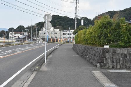 事故が起きた現場。写真の手前右側から車が出てきて歩道左側の道路標識にぶつかった＝伊万里市黒川町