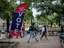 <p>Students and voters walk past a "Vote" sign near a polling location in Austin, Nov. 5, 2024. </p>