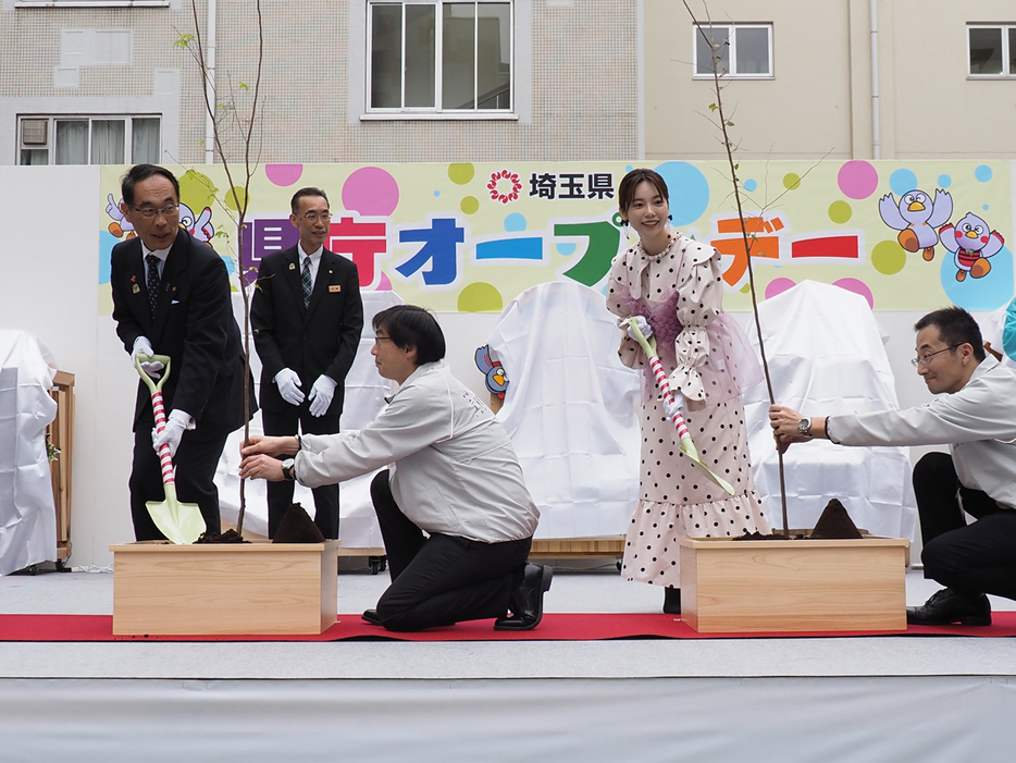 記念植樹を行う大野元裕知事（左）と島崎遥香さん（右）＝１４日、さいたま市