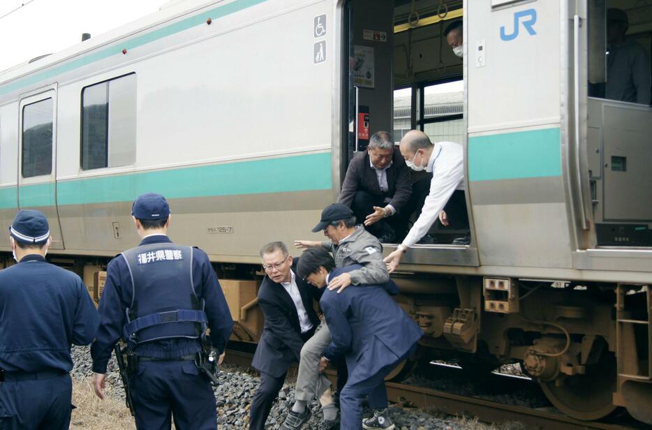 「津波防災の日」の避難訓練で緊急停車した電車から乗客を降ろす参加者＝5日午前、福井県高浜町