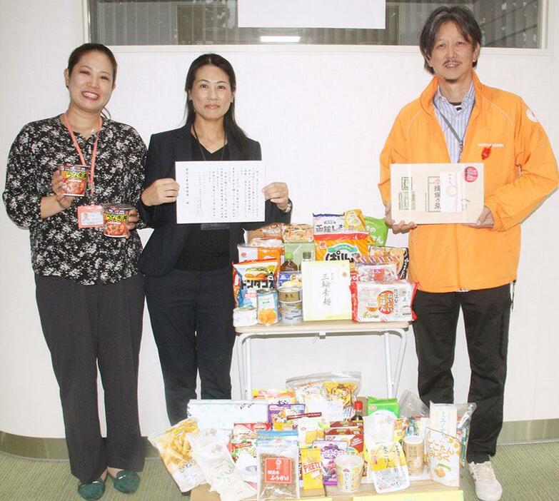 寄贈された食品と感謝状を持つ山岸サブリーダー（真ん中）、柴田課長（右）ら＝殿町で