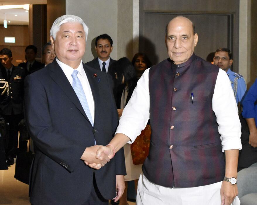 会談前に握手する中谷防衛相（左）とインドのシン国防相＝22日、ラオス・ビエンチャン（共同）