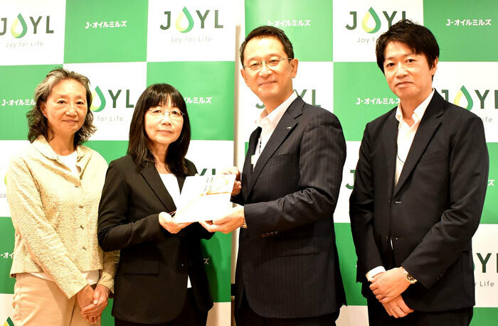 贈呈式で古川光有執贈呈式の模様（左からJEAN小島あずさ氏、吉野美子氏、J-オイルミルズ古川光有執行役員、家庭用油脂マーケティング部・鈴木篤史氏）。