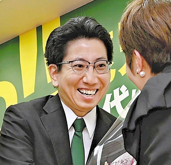 当選確実の知らせを受け、花束を受け取る下鶴さん