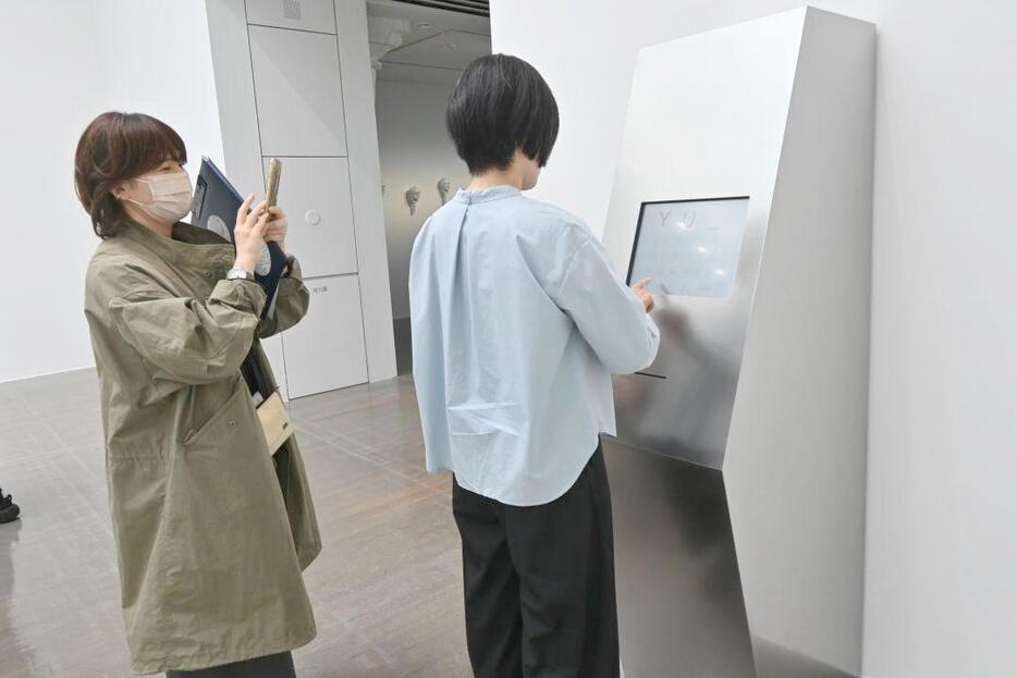 自由に文字を入れ、新作「ATM」を体験する人々=水戸市五軒町