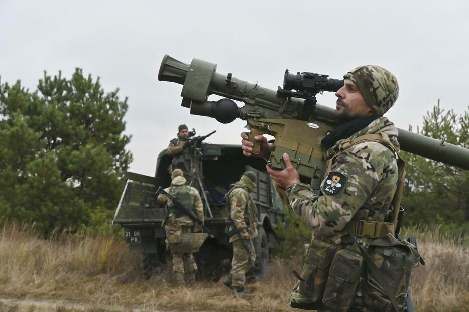 携帯型地対空ミサイルを構えるウクライナ空軍の防空部隊員＝15日、キーウ近郊（共同）