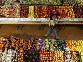 A shopper walks through a produce aisle at a grocery store in Toronto, Ontario. Photographer: Cole Burston/Bloomberg