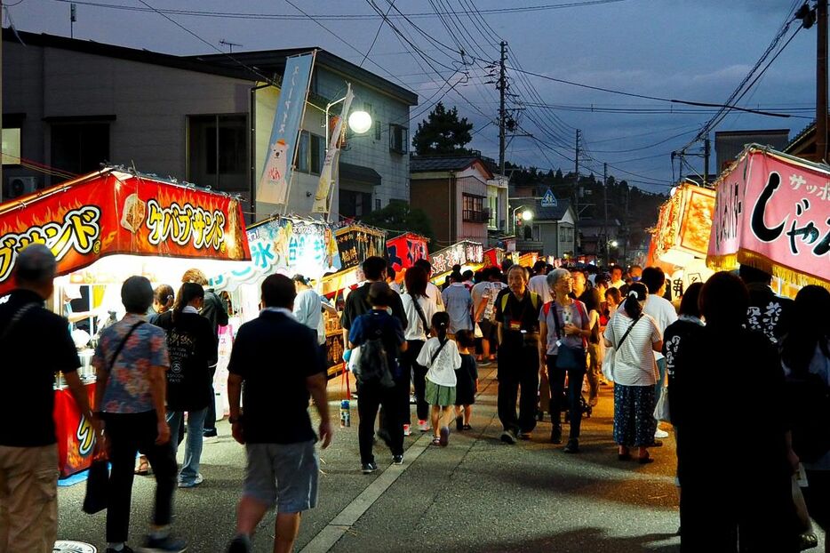 屋台がずらりと並びにぎわう祭りの夜