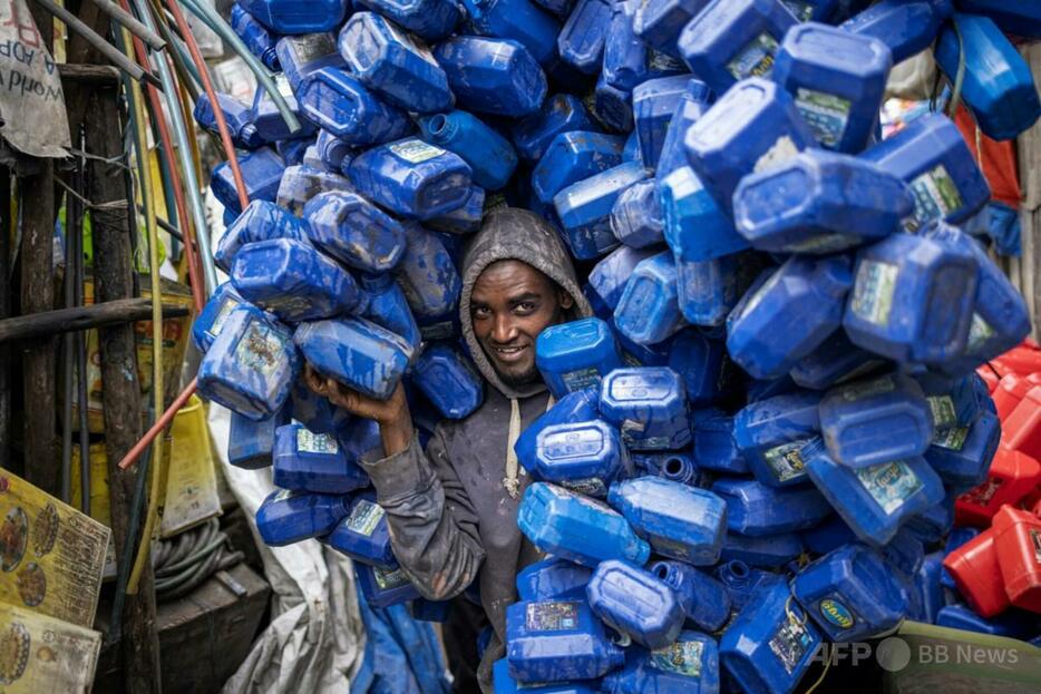 エチオピアの首都アディスアベバの歴史地区メルカトで、プラスチック容器の山を運ぶ廃棄物収集員（2024年10月1日撮影）。【翻訳編集】 AFPBB News