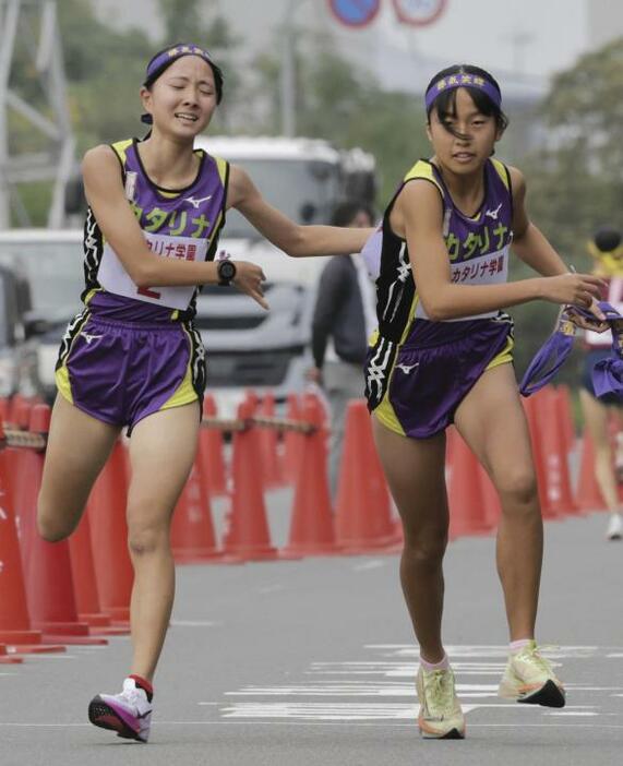 【高校女子】聖カタリナ学園の2区井門（左）からたすきを受け取りスタートする3区宮脇＝香川県坂出市