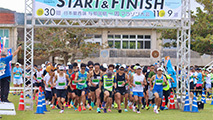 湿った風が流れ込む中、25㌔コースがスタートした＝9日、与那国中学校グラウンド