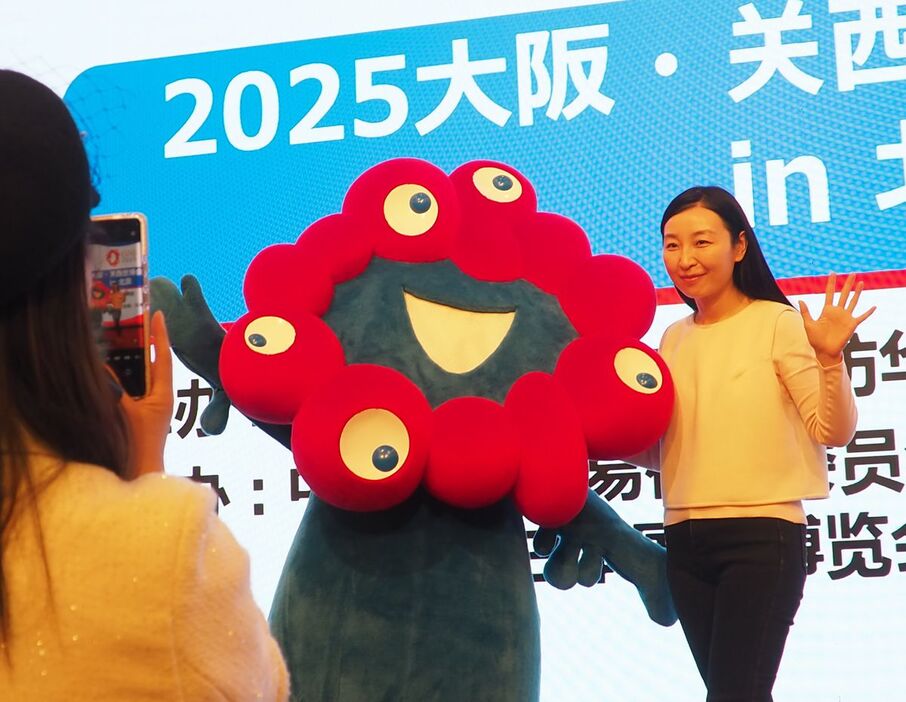 中国・北京市で万博のPRを行う公式キャラクターのミャクミャク（中央）＝27日（井上浩平撮影）