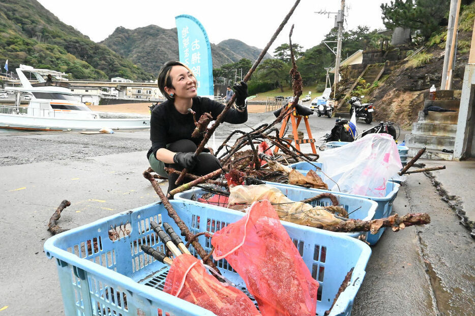 引き揚げられたごみを手に取る白井代表＝松崎町雲見