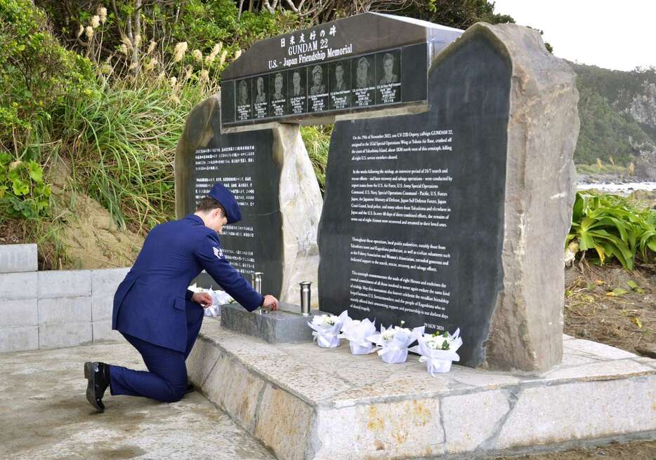 石碑に花を手向ける米兵＝２９日午後２時２０分ごろ、屋久島町船行