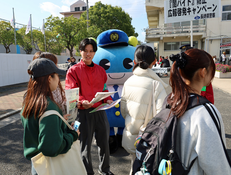 闇バイトに手を出さないよう学生に呼びかける学生サポーターの岩谷さん（中央）＝佐世保市川下町、県立大佐世保校