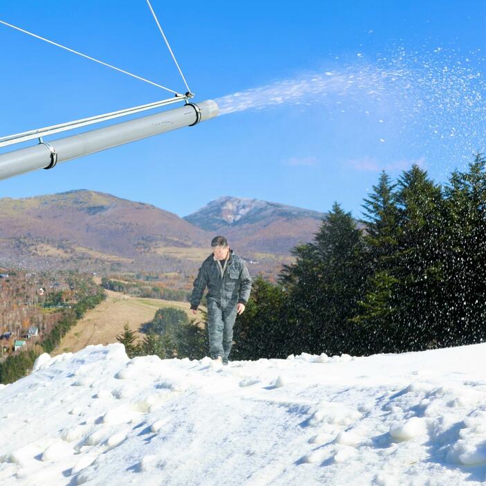 人工造雪機から出てくる雪を踏んで確かめる佐藤副社長＝8日昼ごろ