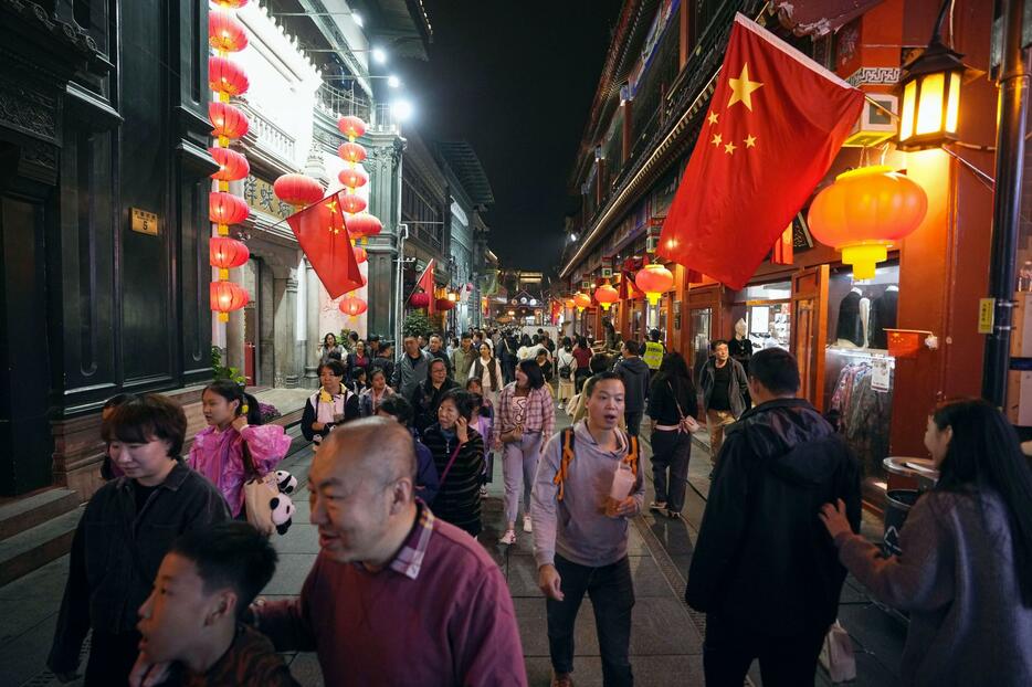 北京市内の繁華街を歩く人たち＝10月（共同）