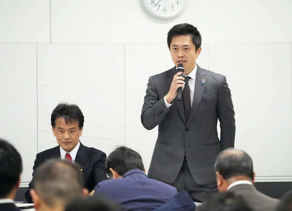 兵庫維新の会全体会議の冒頭、あいさつする日本維新の会の吉村洋文共同代表。左は兵庫維新の会の片山大介代表＝24日午前、神戸市中央区（恵守乾撮影）