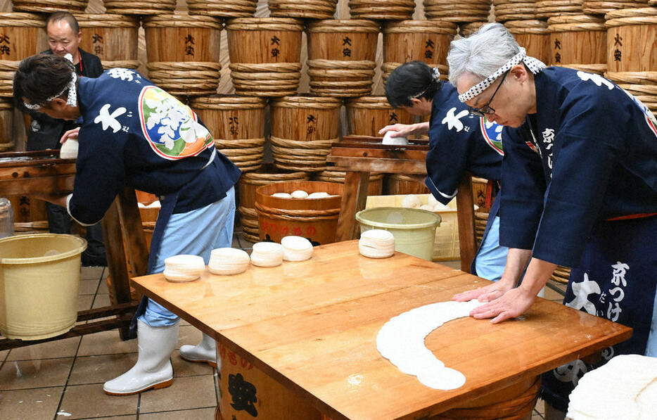 皮をむいた聖護院かぶらをかんな（奥）でスライスし、半円状に広げ、虫食いを確認しながら塩を振って３日間寝かせる＝京都市左京区で、日高沙妃撮影