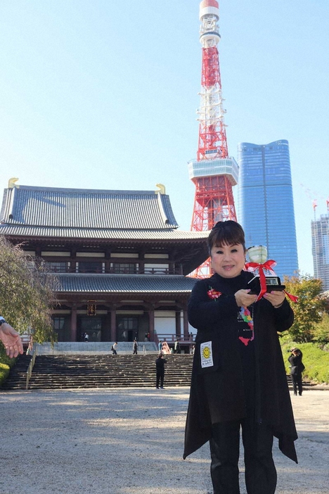 増上寺と東京タワーをバックにトロフィーを掲げる天童よしみ（撮影・菊地一）