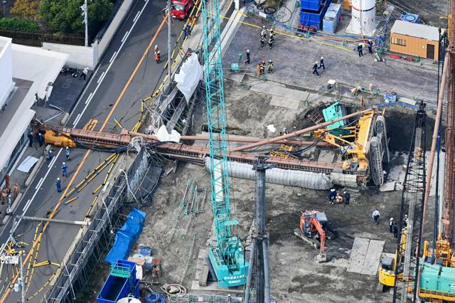 大型の重機が倒れ、道をふさいだ現場=2024年11月5日午前11時14分、大阪市都島区、朝日放送テレビヘリから、水野義則撮影