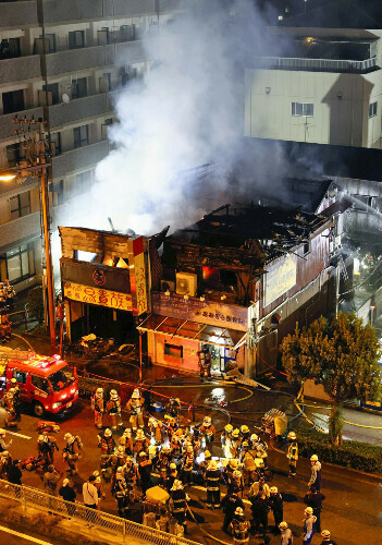 火災で白煙を上げる居酒屋（左）と整骨院（１０日午前１時２１分、大阪市東成区で）＝前田尚紀撮影