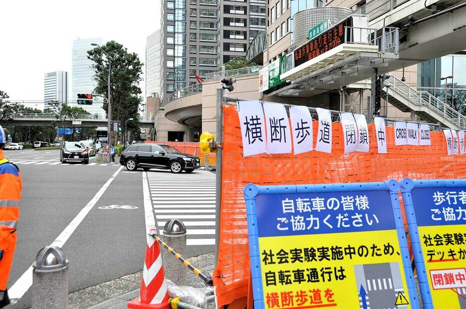 フェンスで封鎖された横断歩道と通り過ぎていく左折車（中央奥）＝５日午後、横浜市西区