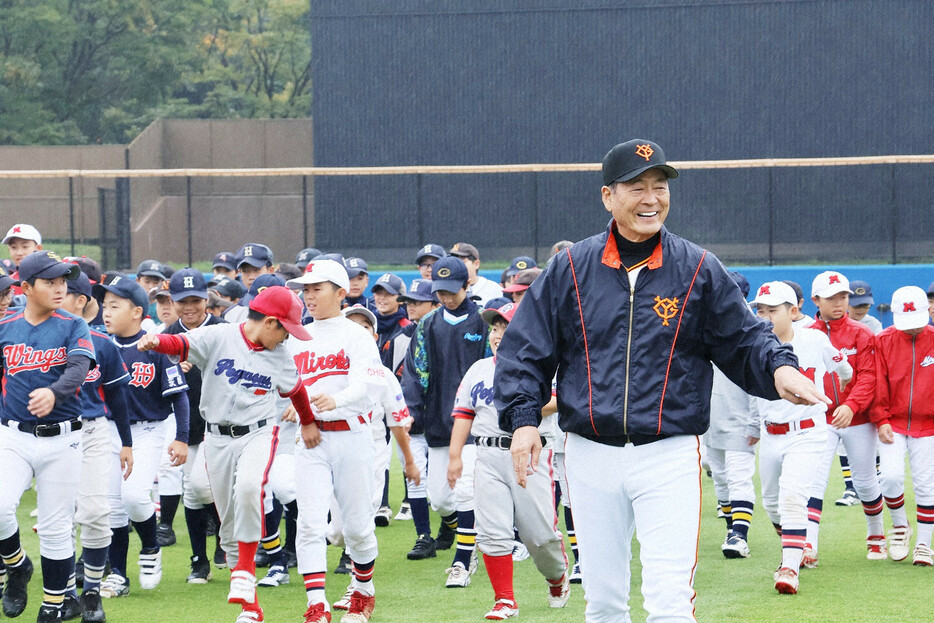 雨の中、中畑清さんの指導でウオーミングアップをする地元の小学生ら＝千葉県佐倉市で2024年11月2日午前9時半、大槻英二撮影