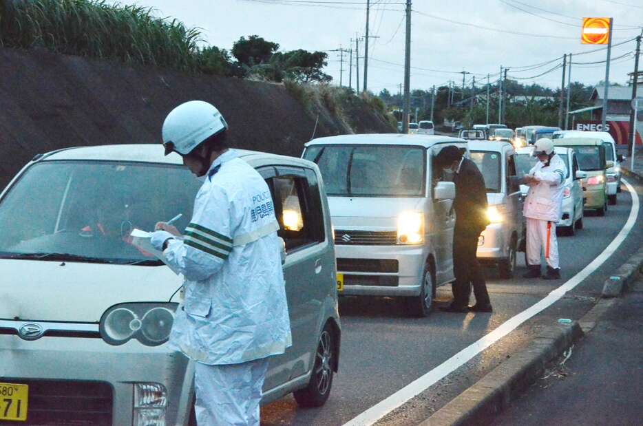 発生時間帯に合わせ現場付近で検問する徳之島署員ら＝２１日、伊仙町佐弁