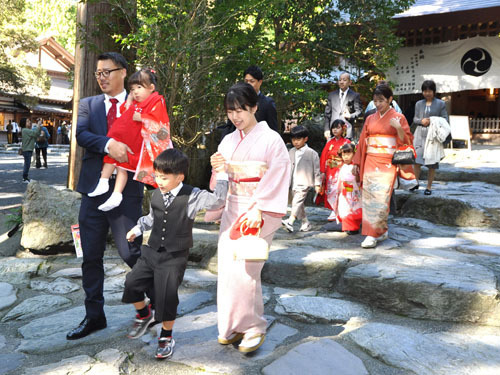 【晴れ着姿の子どもの手を引く保護者ら＝鈴鹿市山本町の椿大神社で】