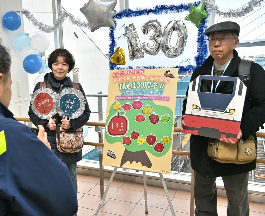 カウントダウンボードの前で記念撮影する観光客＝青森駅