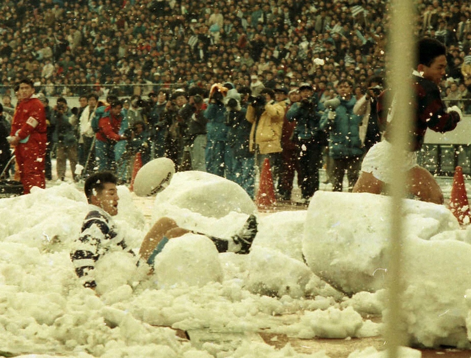 87年、早大・堀越(右)のタックルでタッチライン近くの雪山に激突した明大・吉田