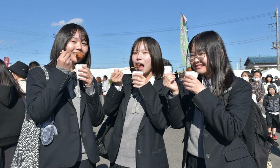 コロッケを頬張る高校生=龍ケ崎市役所駐車場