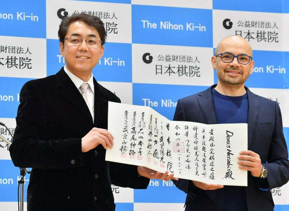 日本棋院の武宮陽光理事長から9段免状を受け取るノーベル化学賞受賞者で囲碁AI「アルファ碁」の開発者のデミス・ハサビス氏（右）＝21日、日本棋院（三尾郁恵撮影）