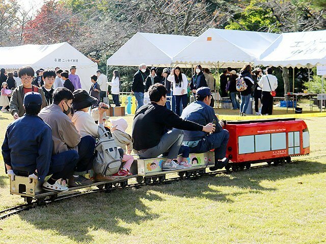 ミニアイトラムの乗車を楽しむ親子連れ