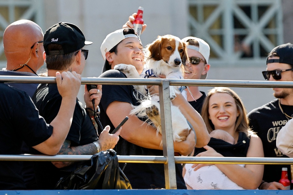 24MLBワールドシリーズ制覇を果たし、愛犬デコピンを抱いて優勝パレードに臨むロサンゼルス・ドジャースの大谷翔平（中央、2024年11月1日撮影）。【翻訳編集】 AFPBB News