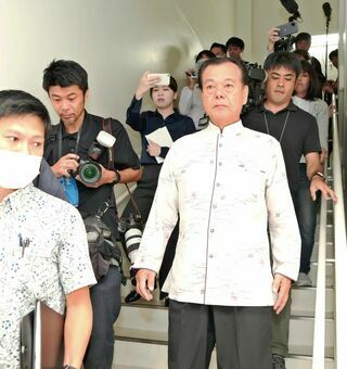 会見を打ち切り、庁舎を出る古謝景春南城市長（右）。記者団が庁舎外まで追いかけた＝８日午前９時８分、同市役所（古謝克公撮影）