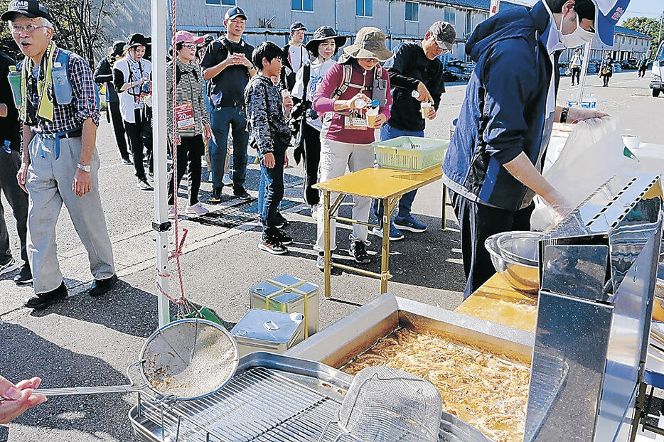 揚げたてのガスエビ唐揚げに列をつくる参加者＝加賀市橋立漁港