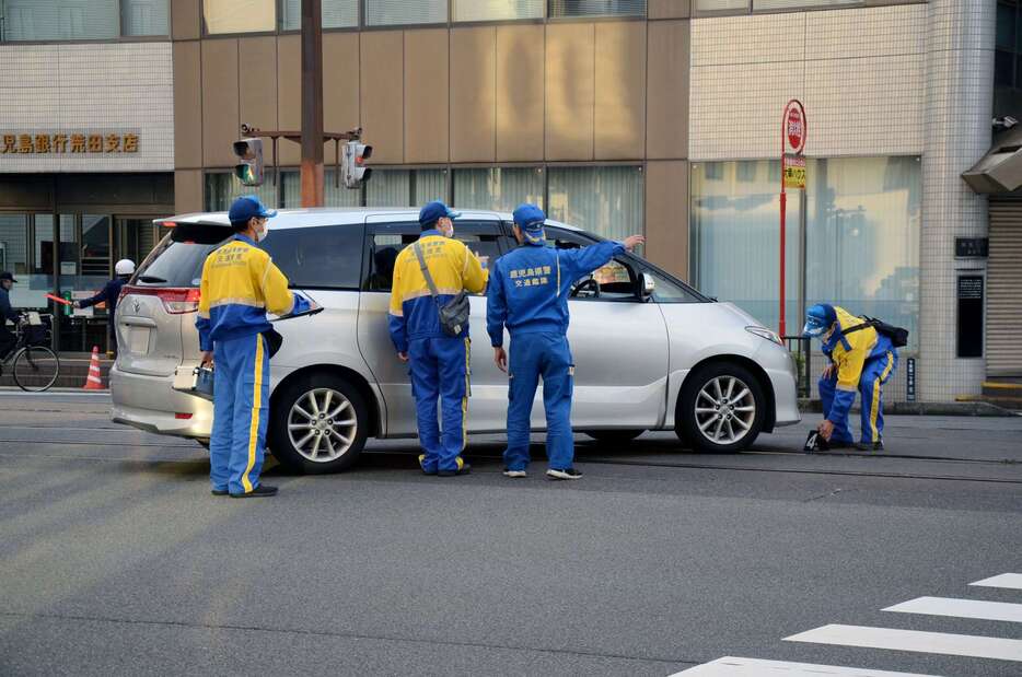 現場検証のため容疑者を乗せた乗用車＝３０日朝、鹿児島市の下荒田１丁目（画像は一部加工してあります）