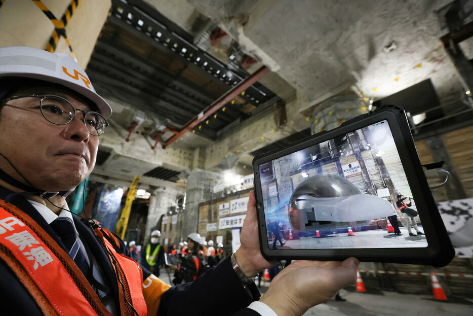 ＪＲ東海は４日、リニア中央新幹線の始発駅となる品川駅の近隣住民向けの工事現場見学ツアーを公開した。参加者は拡張現実（ＡＲ）技術を活用したリニアの走行動画をタブレット端末で見るなどしていた＝東京都港区