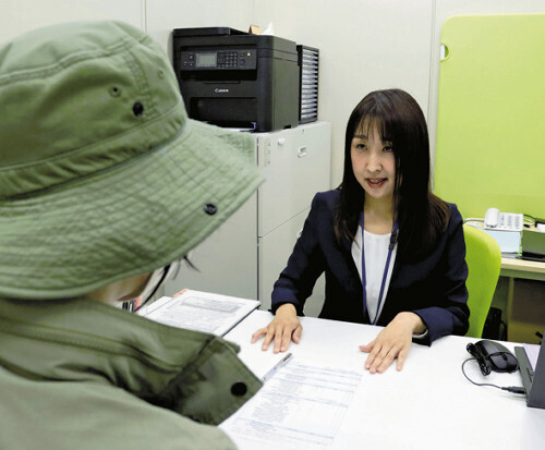 おくやみコーナーで利用者に手続きを説明する担当者（川崎市高津区で）