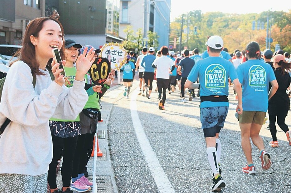 うちわや声援でランナーを元気づける女性たち＝高岡市広小路